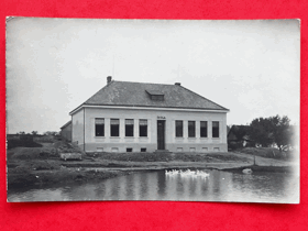 Budova školy u rybníka (pohled)